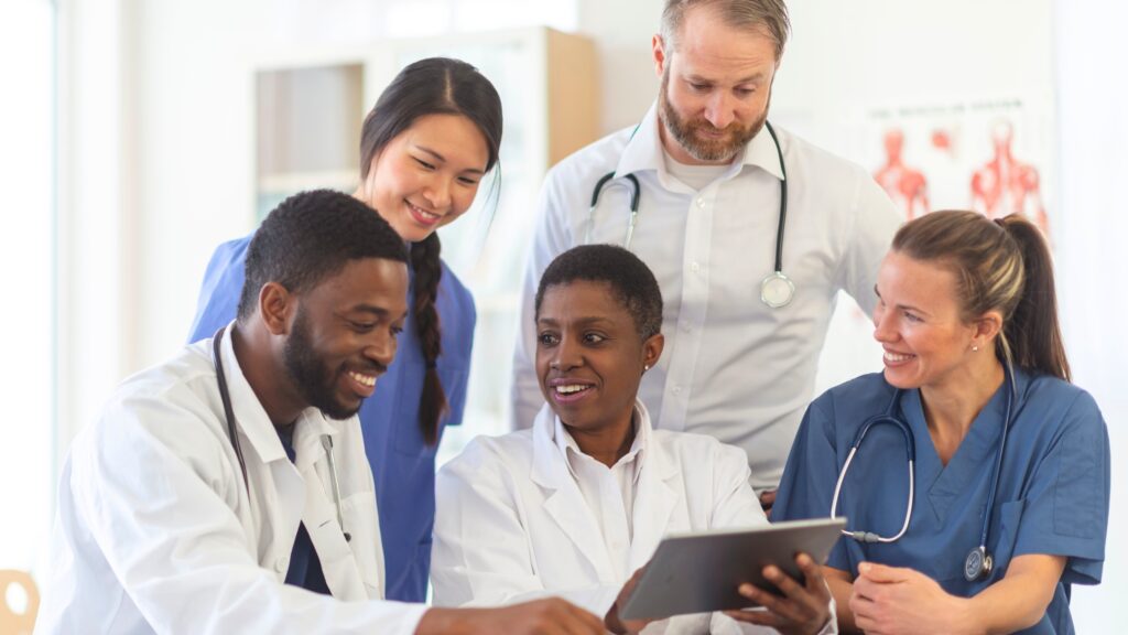 A medical team gathers around a tablet to choose personal X-ray dosimeters.