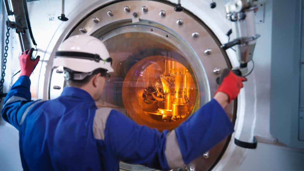 A nuclear engineer works with a radiation source while wearing an electronic personal dosimeter.